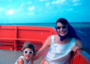 The author, aged 3, is wearing large white sunglasses next to her 29 year-old mother on the Port Aransas, Texas ferry.